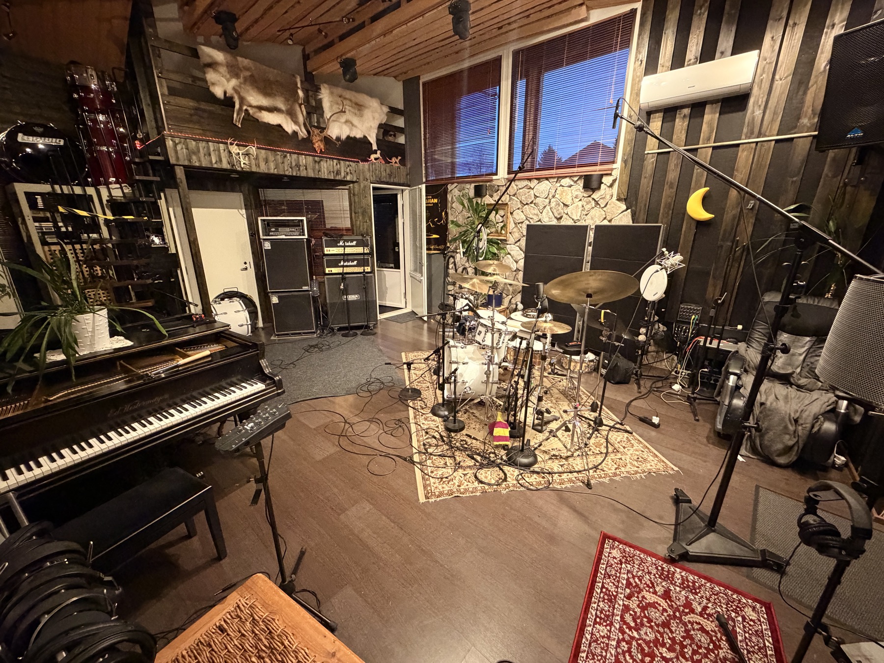 Live room with a grand piano, drums and amplifiers