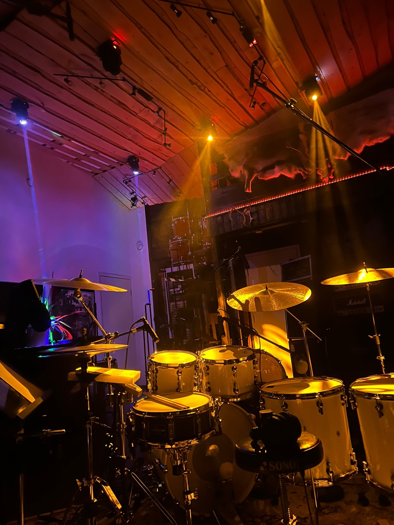 Drum kit under warm coloured studio lighting